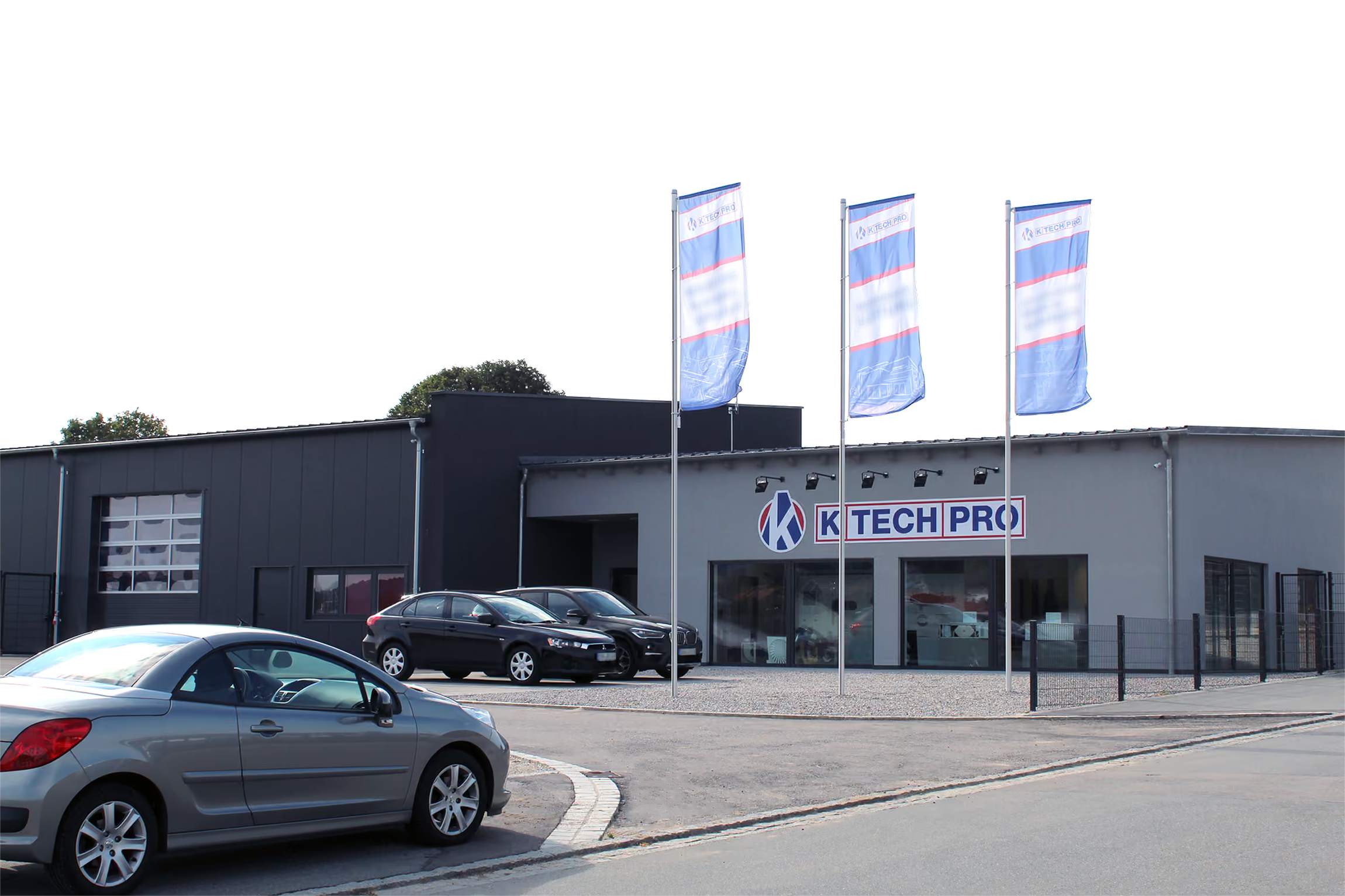 Firmengebäude der K-TECH-PRO GmbH mit Firmenschild und Fahnen